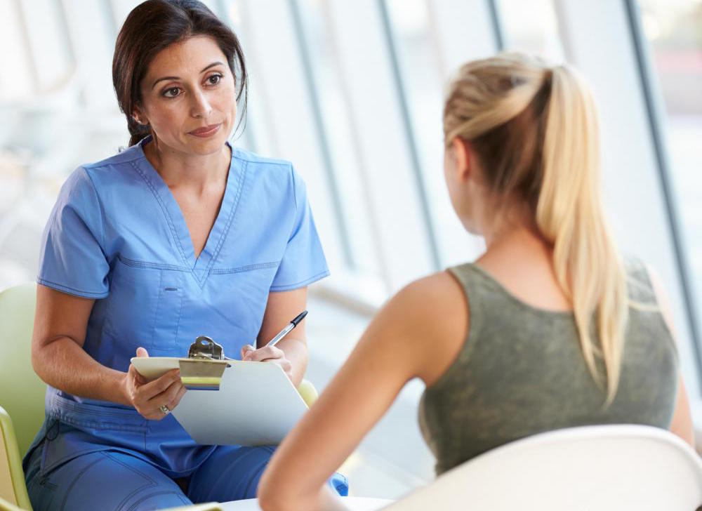 female-nurse-talking-to-woman-with-clipboard