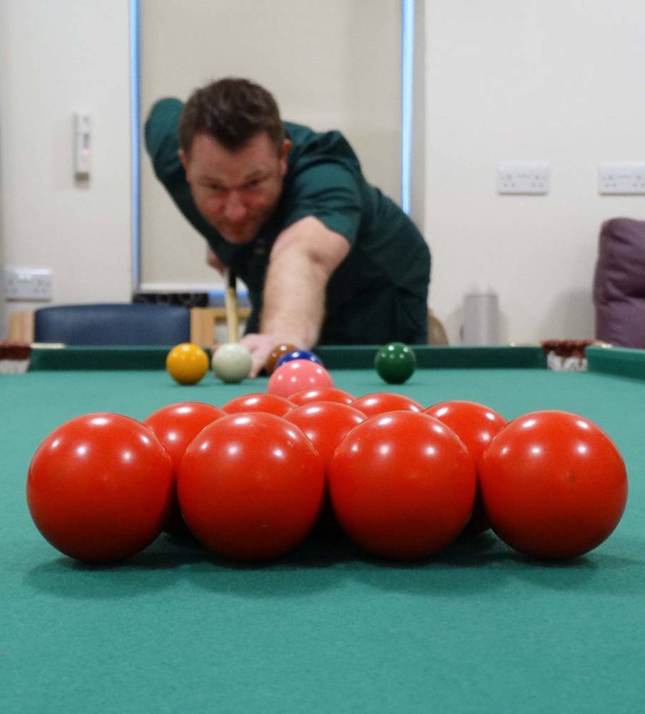 Health care support worker Andrew Ross enjoys a game of pool. Image: Abertawe Bro Morgannwg University Health Board