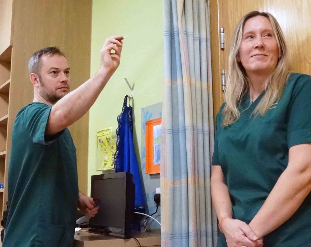 Health care support workers Leon Williams and Michelle Nicholls play darts. Image: Source: Abertawe Bro Morgannwg University Health Board.