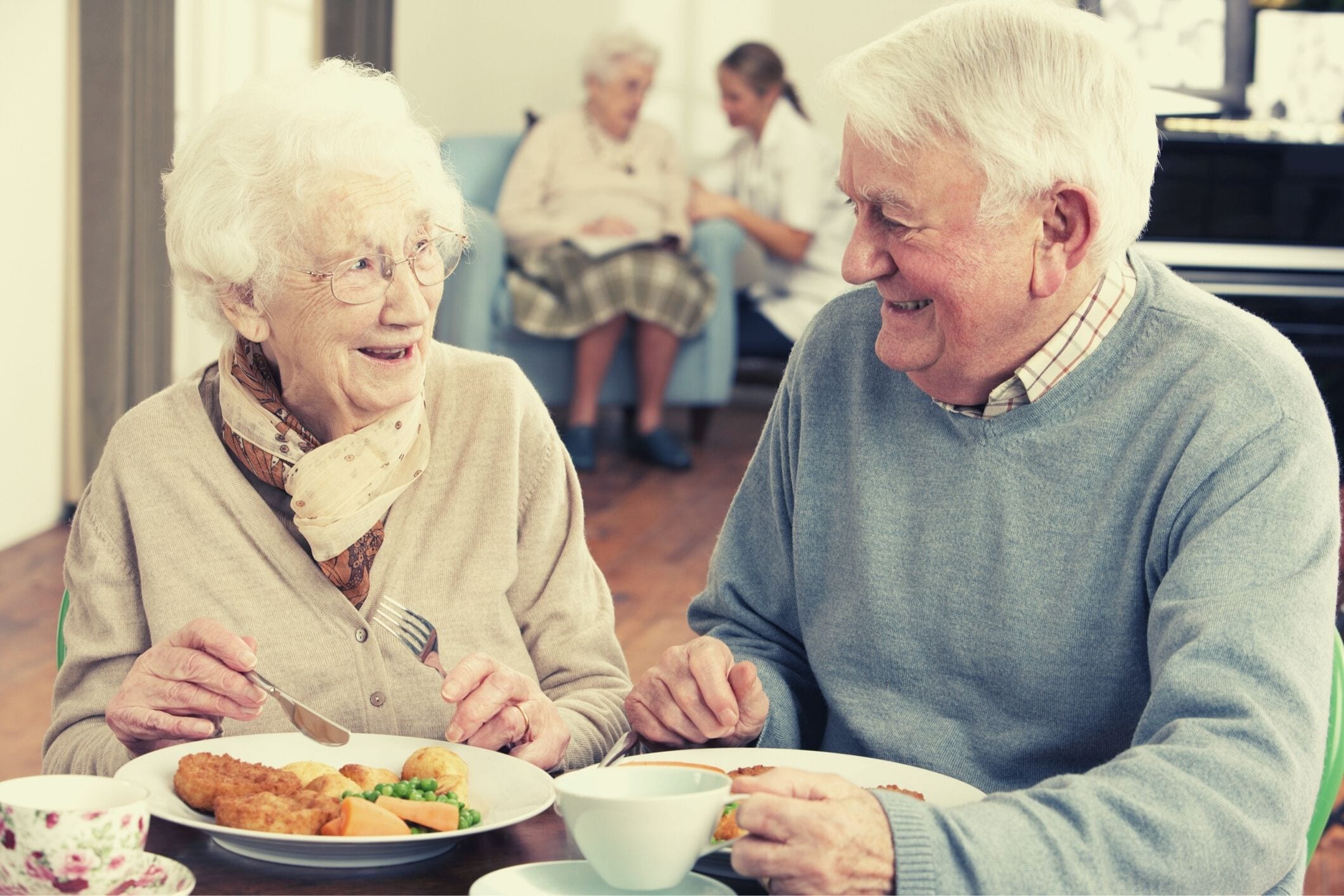 Senior couple eating meal in care home