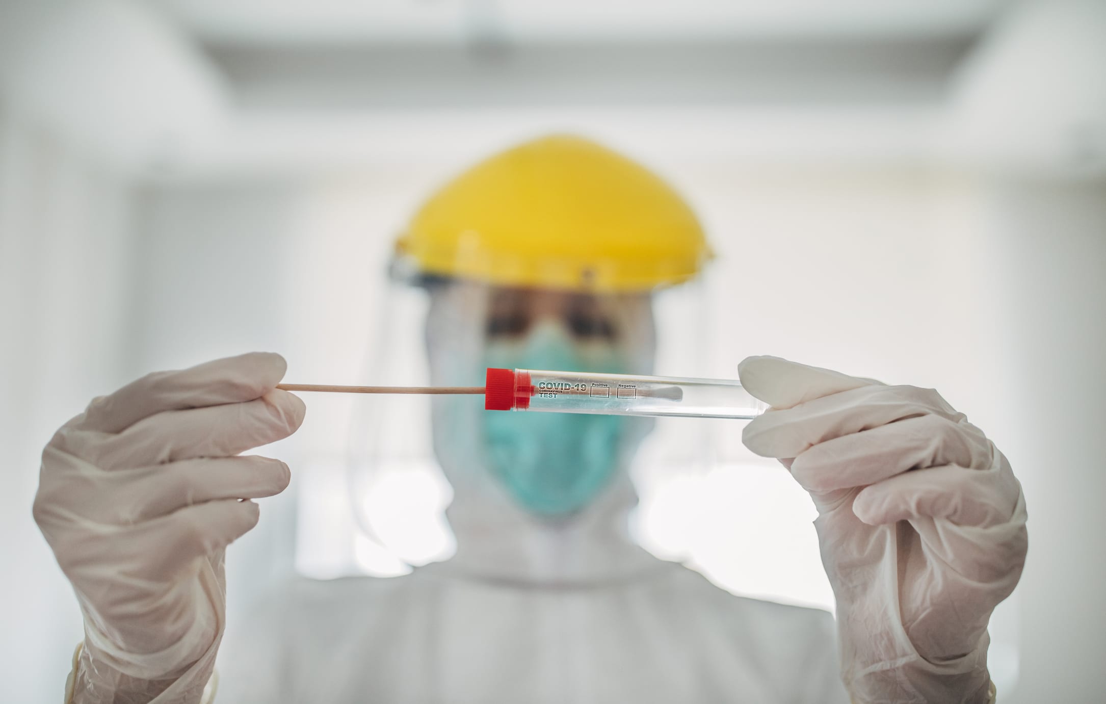 Doctor showing covid-19 tube test and sampling swab