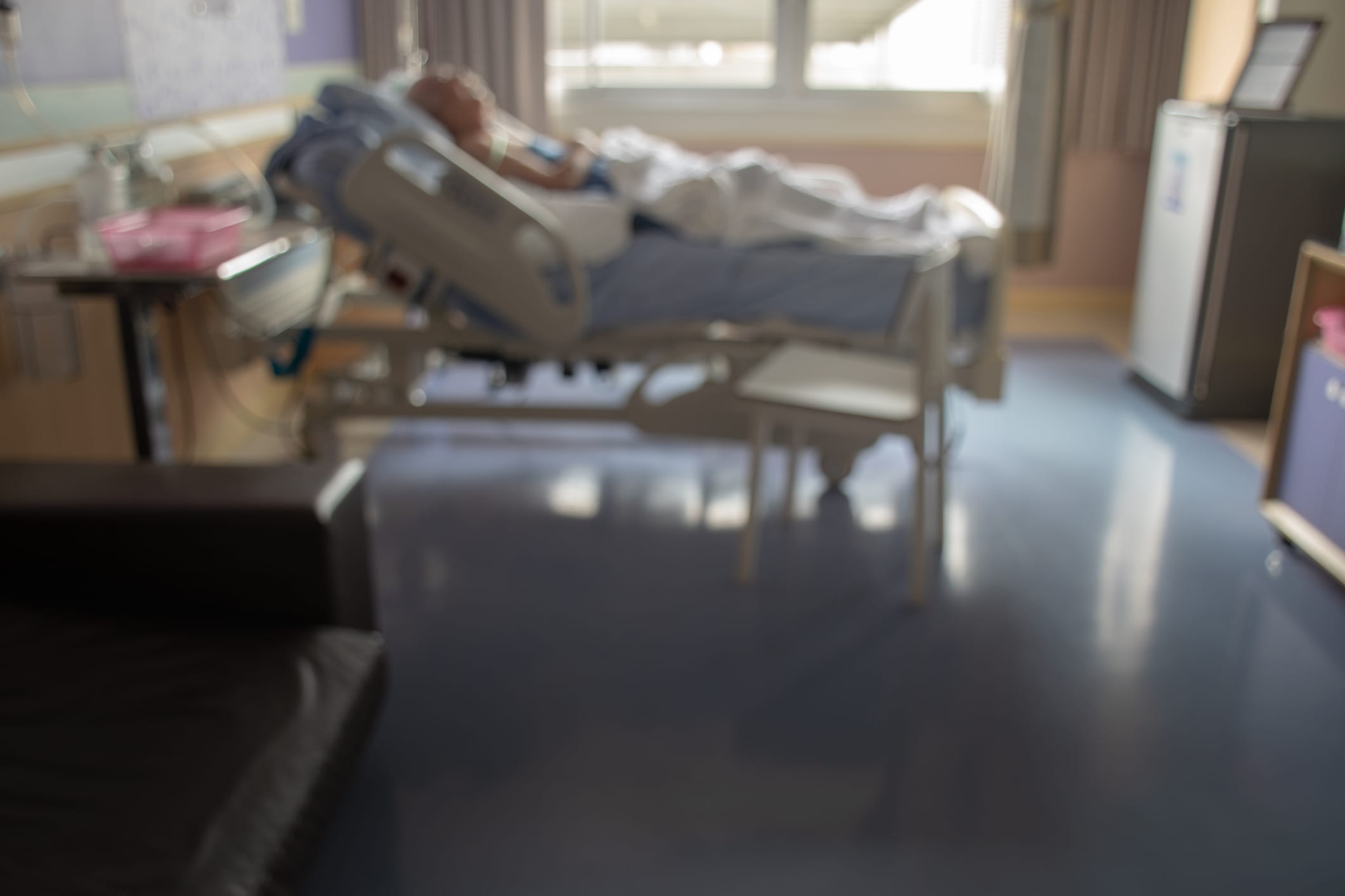 blurred image of Patient with drip in hospital for background usage.