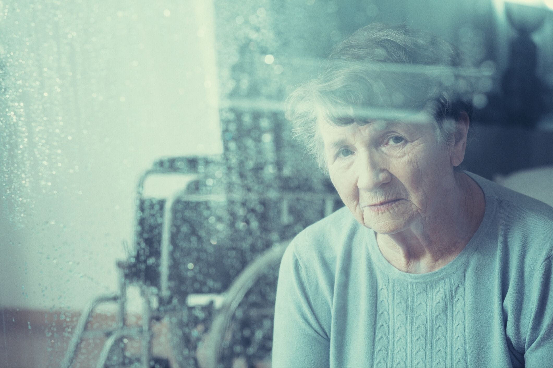 Elderly woman looking out window