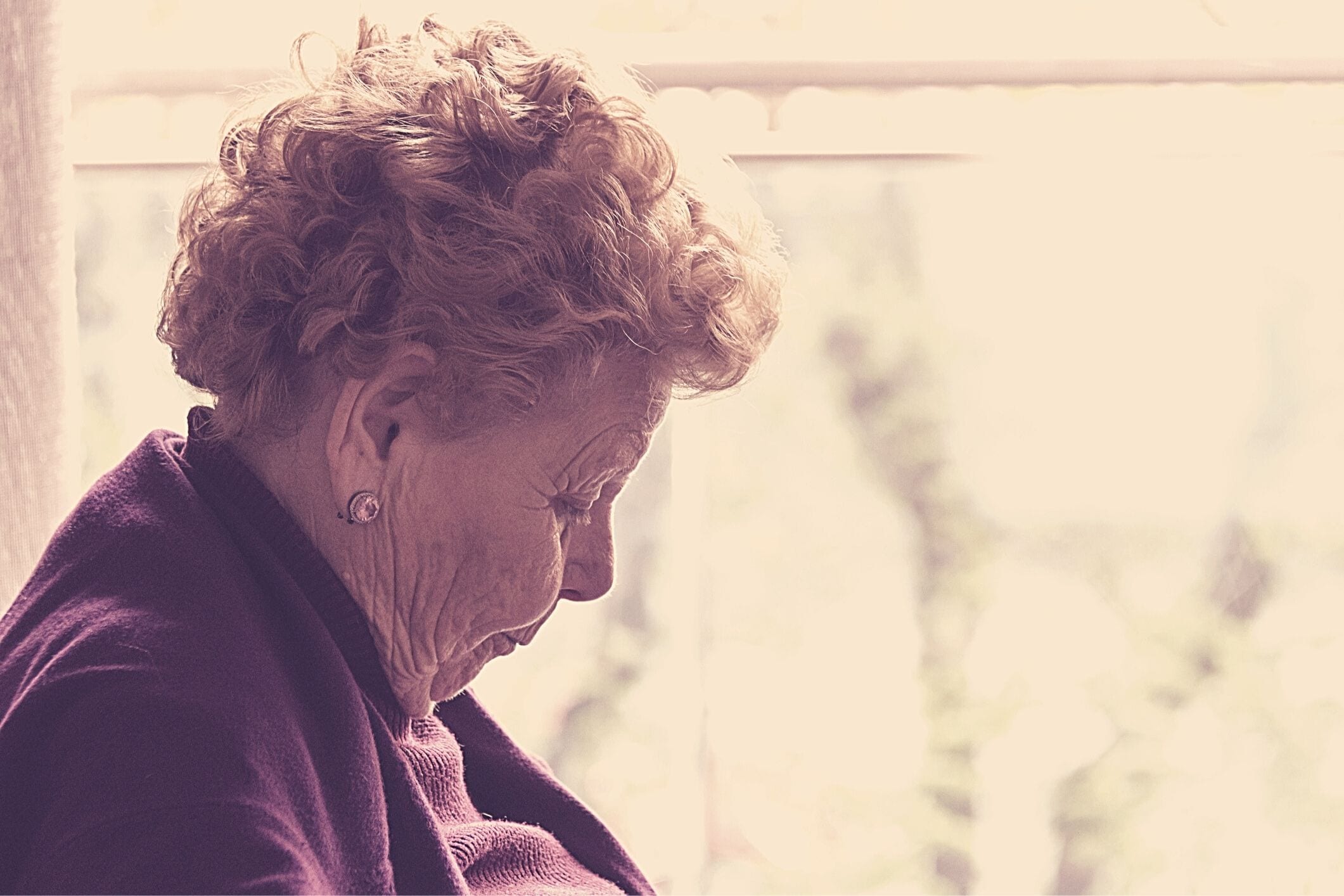 Elderly woman sitting by window