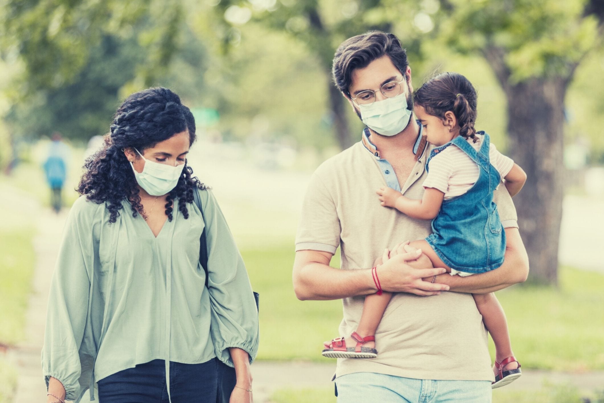Family wearing masks walking