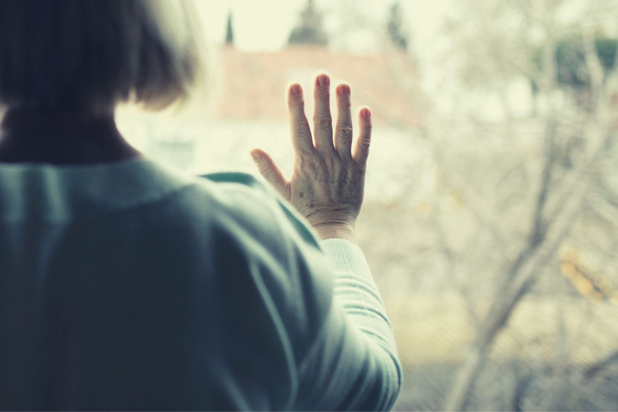 Sad elderly woman window