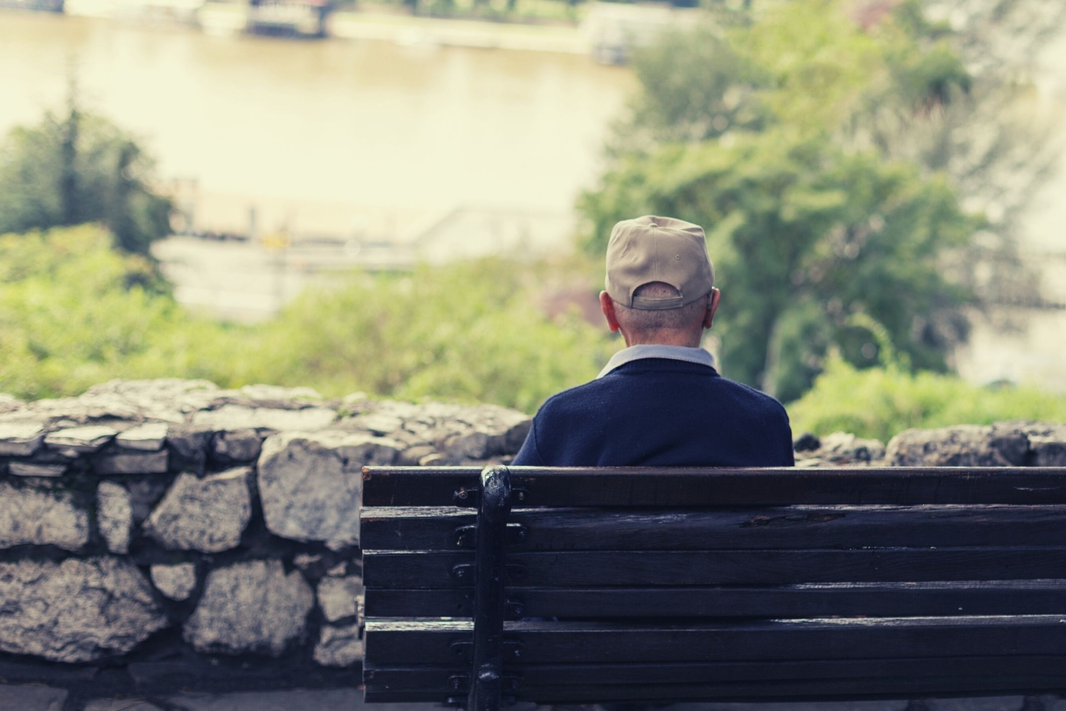 Lonely man sitting on park bench