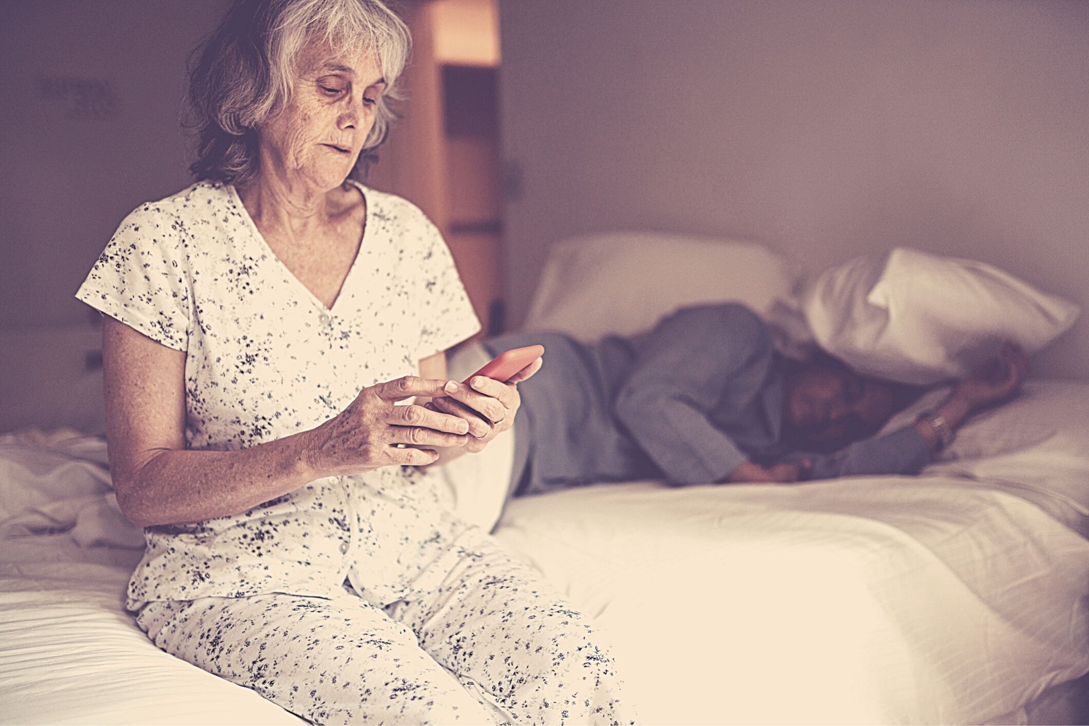 Senior woman in bed mobile phone