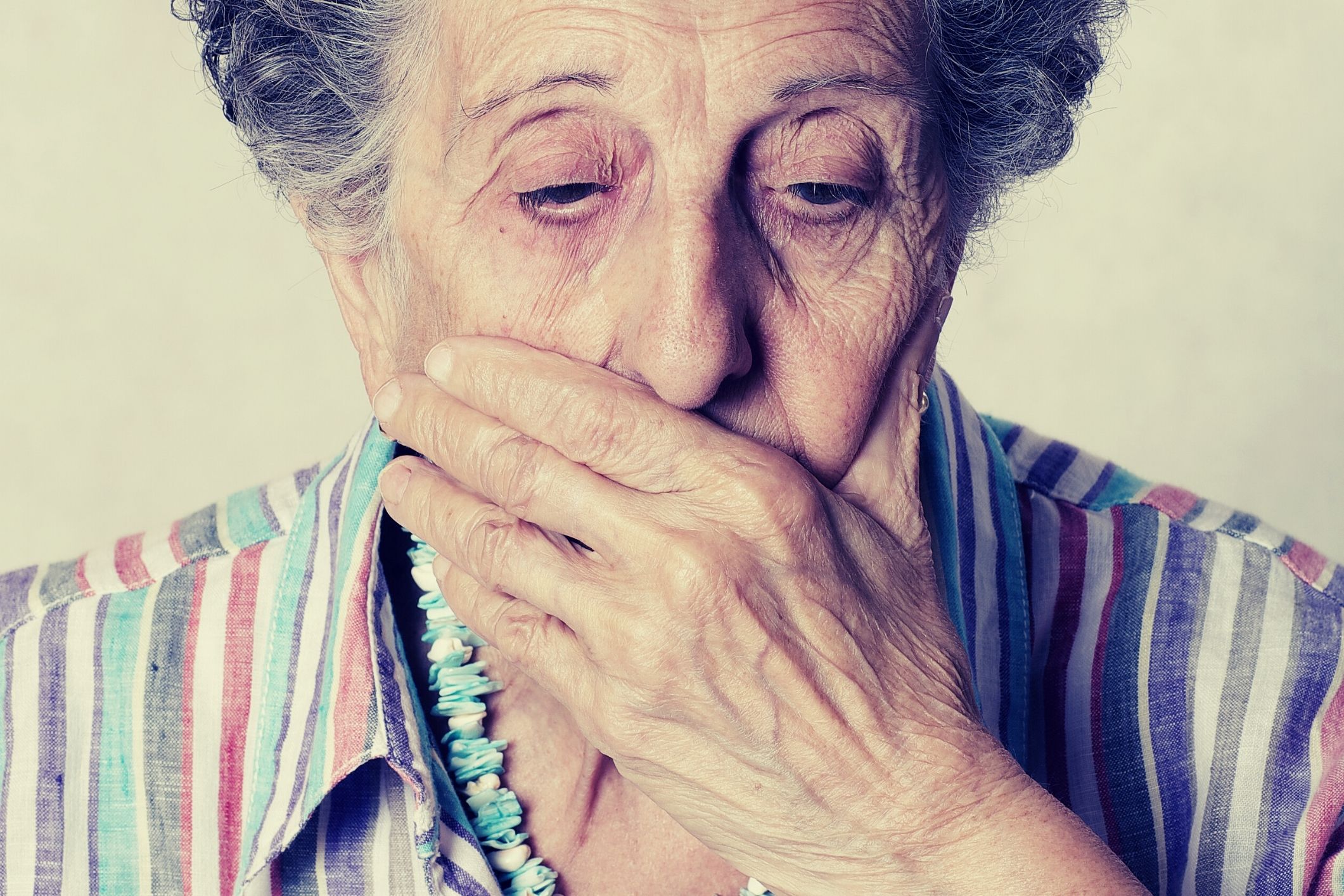 Elderly woman ashamed of her teeth