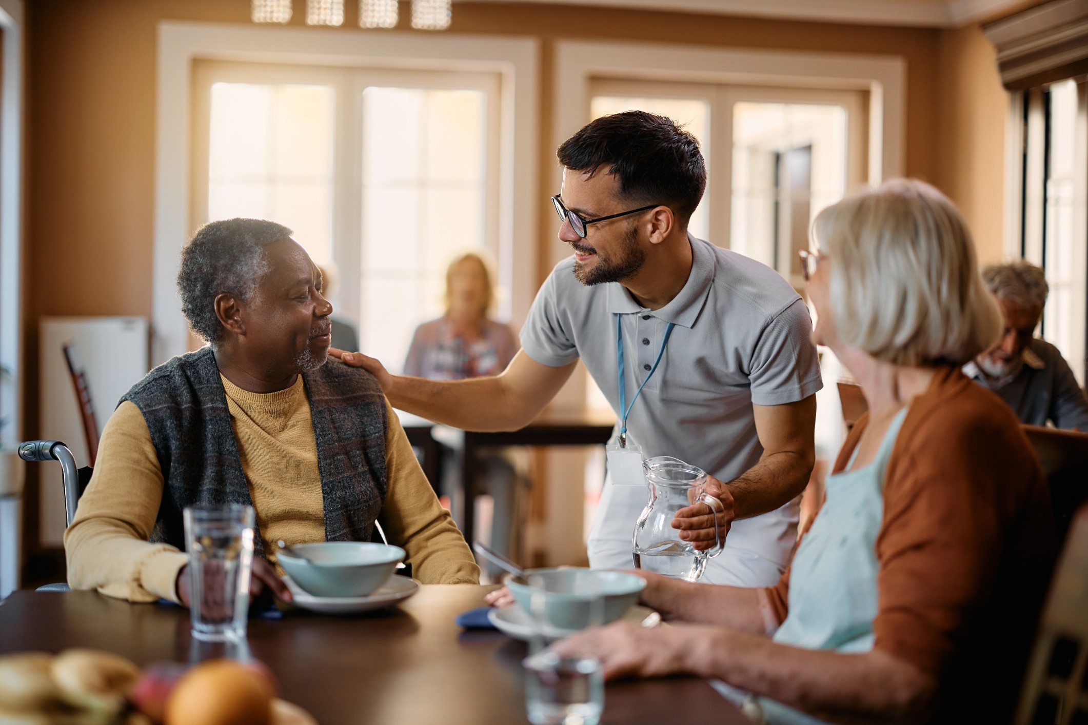 aged care workers gives food to residents